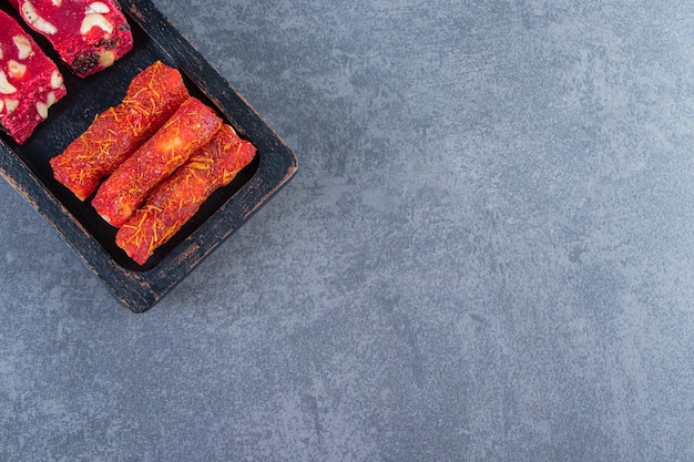 Traditional Turkish delights on a wooden plate , on the marble background.