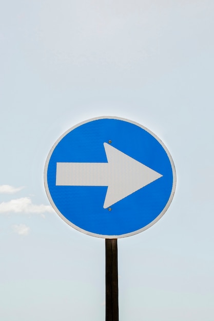 Traffic arrow sign and sky with clouds