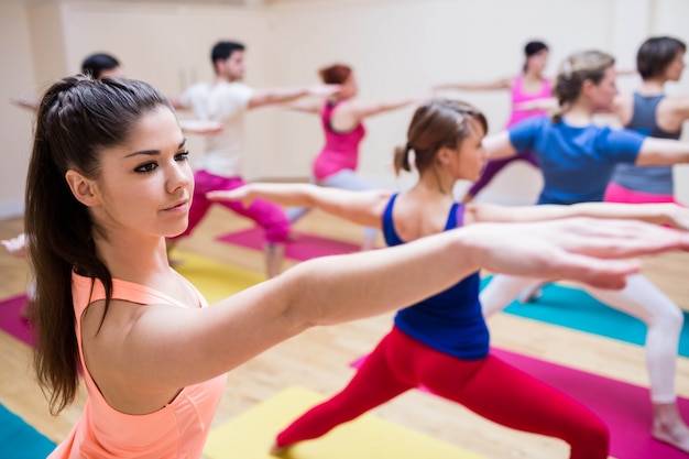 Trainer assisting group of people with stretching exercise