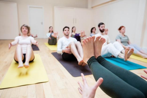 Trainer assisting group of people with stretching exercise