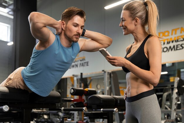 Trainer helping beginner at the gym