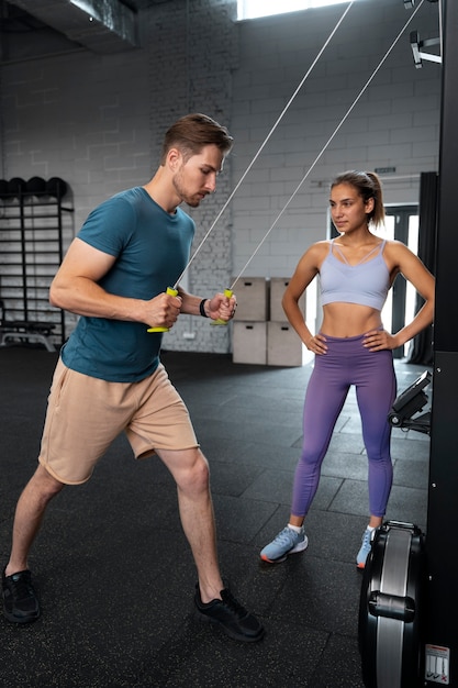 Trainer helping beginner at the gym