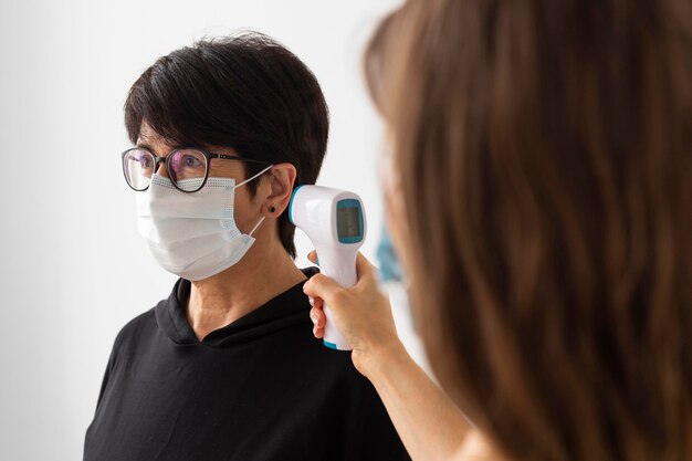 Trainer scanning a woman temperature