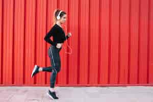 Free photo training woman in headphones on street