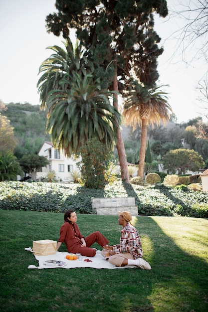 Free Photo trans couple talking while having a picnic at the park