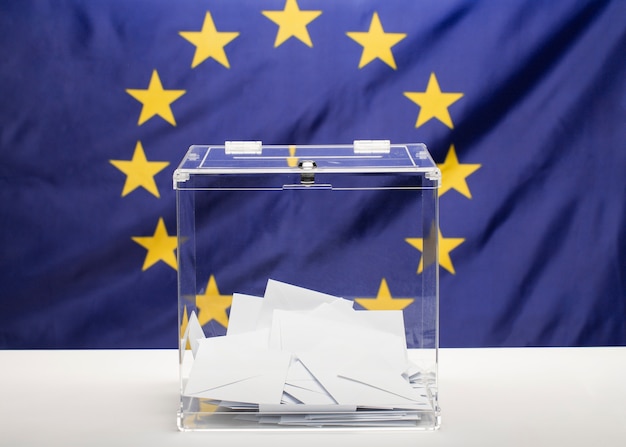 Free photo transparent ballot box filled with white envelope and european union flag