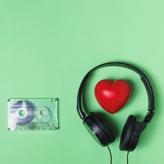 Transparent cassette tape; headphone and red heart on green background