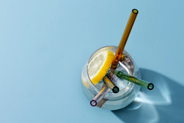 Transparent glass with fizzy water and colored glass straws