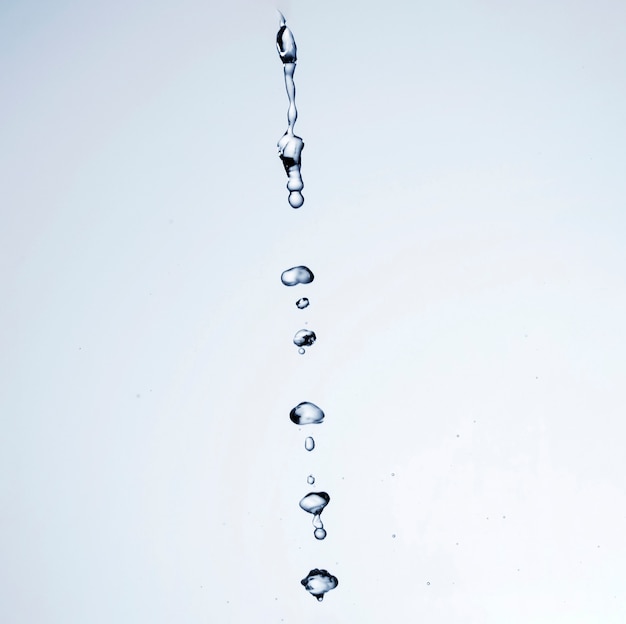 Transparent liquid drops on white background with copy space