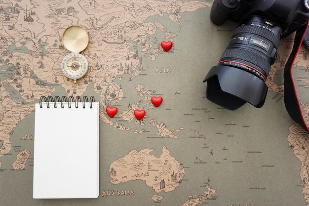 Free photo travel composition with blank notebook, camera and red hearts