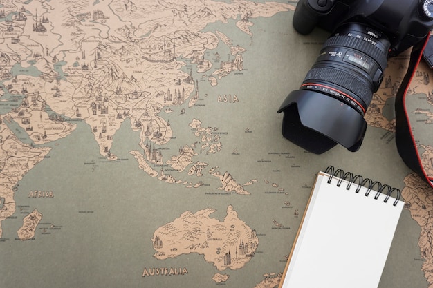 Free Photo travel composition with vintage map, camera and blank notebook