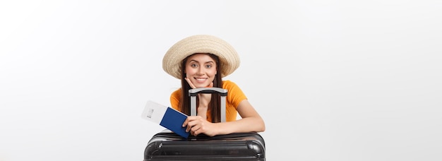 Free photo travel concept studio portrait of pretty young woman holding passport and luggage isolated on white