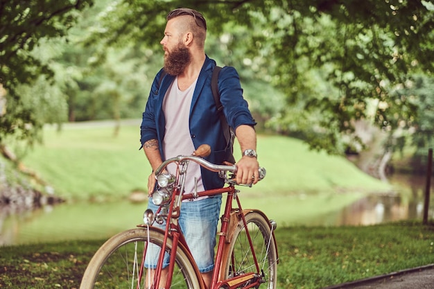 A traveler dressed in casual clothes with a backpack, relaxing in a city park after riding on a retro bicycle.