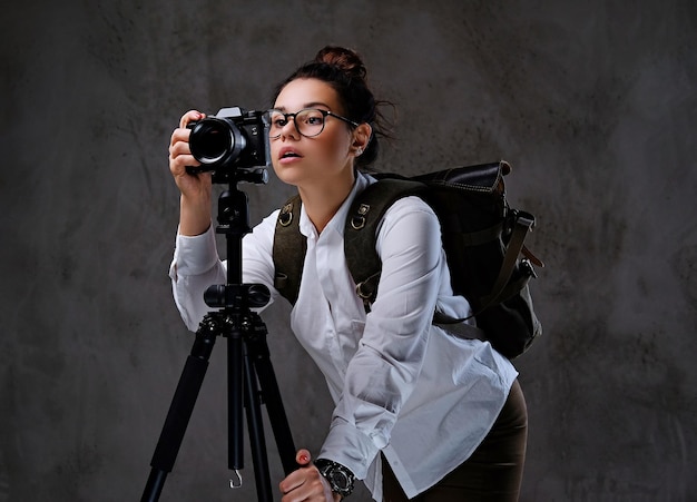 Free photo traveler female taking pictures with a digital camera on a tripod.