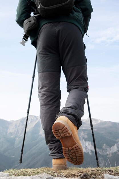 Traveler hiking on mountains while having his essentials in a backpack