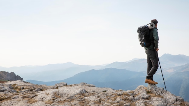 Free photo traveler hiking on mountains while having his essentials in a backpack