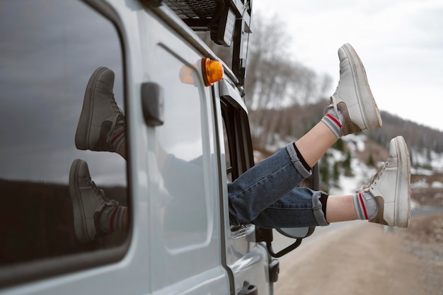 Free Photo traveler holding legs out the window close up