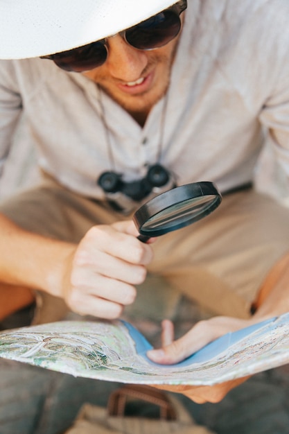 Free photo traveler looking at the map through the loupe