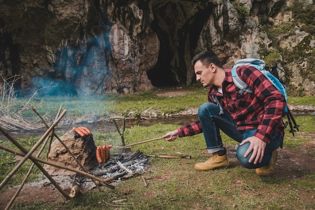 Traveler preparing sausages outdoors