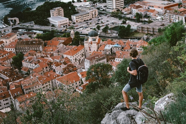 Traveler standing on a mountain and looking on evening the old town of Kotor Montenegro