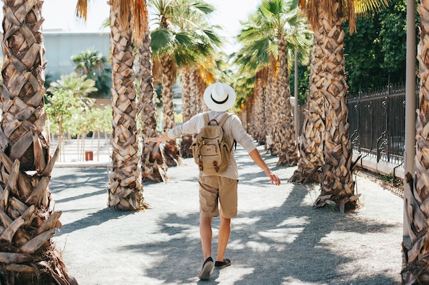 Free Photo traveler walking through palm trees