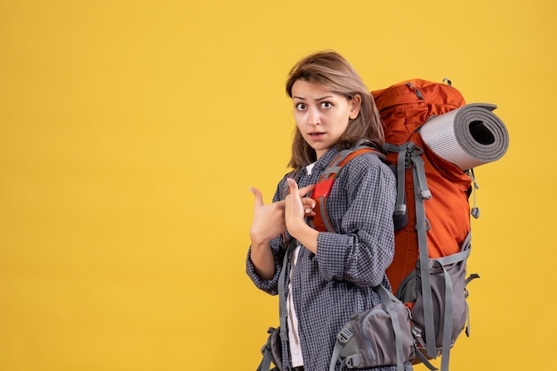 Free photo traveler woman with red backpack pointing at herself