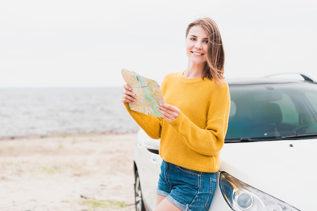 Traveling woman holding a map facing the camera