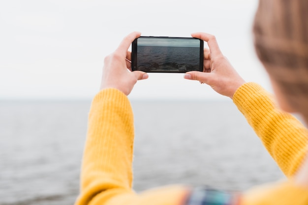 Free Photo traveling woman taking picture of the sea