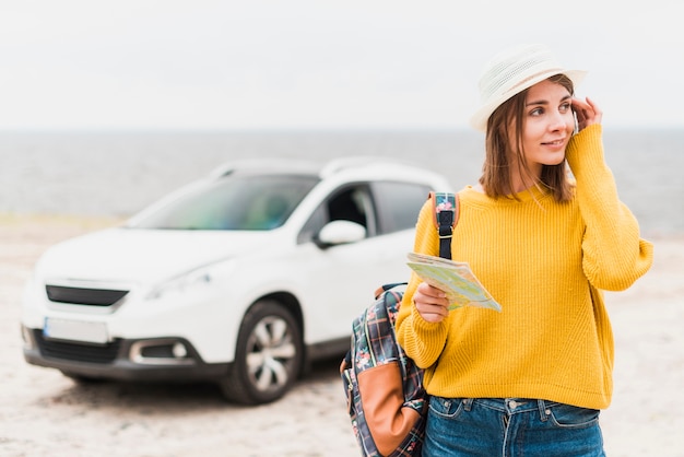 Free photo traveling woman with car in the background