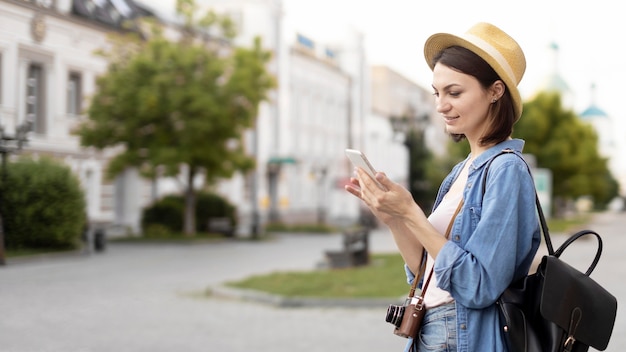 Traveller with hat browsing mobile phone