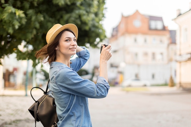 Traveller with hat taking pictures outdoors