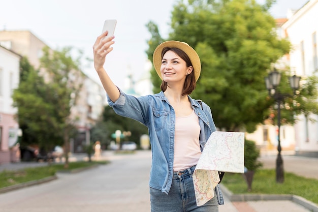 Traveller with hat taking pictures outdoors