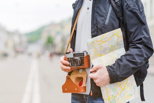 Free photo traveller with map and camera on street