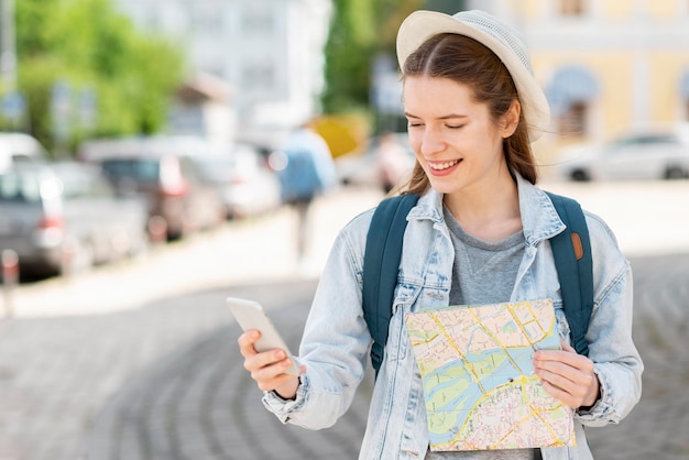 Traveller with map and mobile phone medium shot