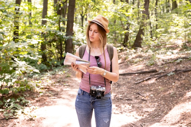 Free photo traveller in woods looking at map