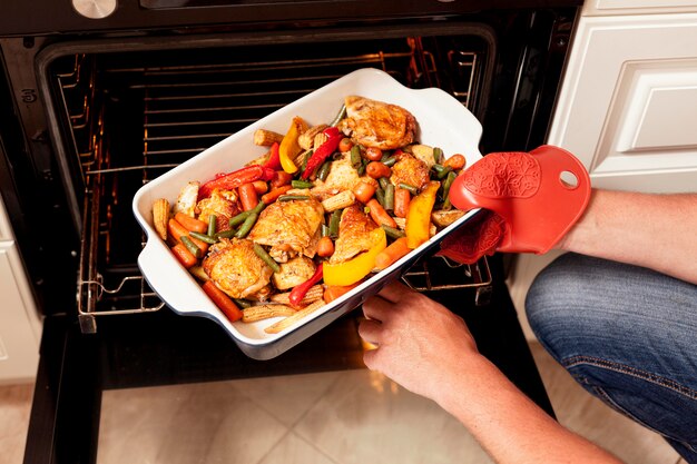 Tray of food being put into oven to cook