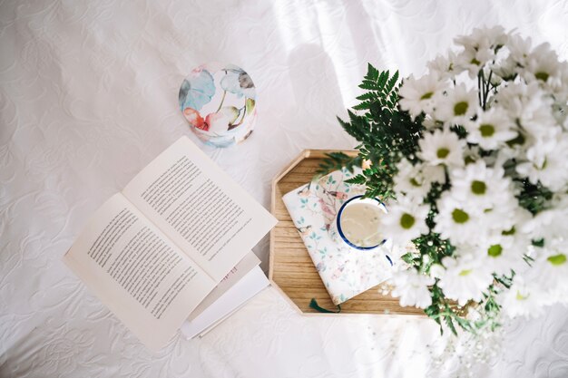 Tray with bouquet near opened book