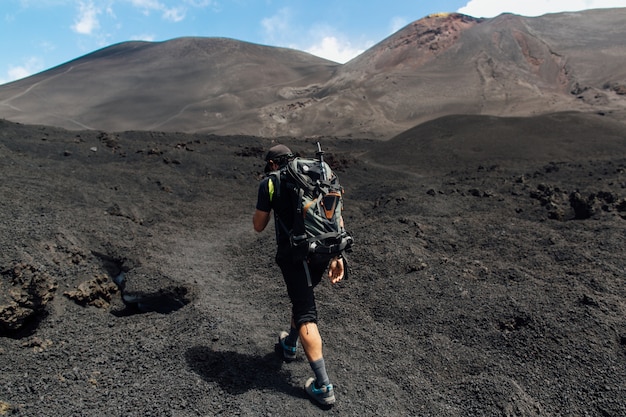 Trekking at peak volcano.Hiker climbing at crater volcano Etna in Sicily