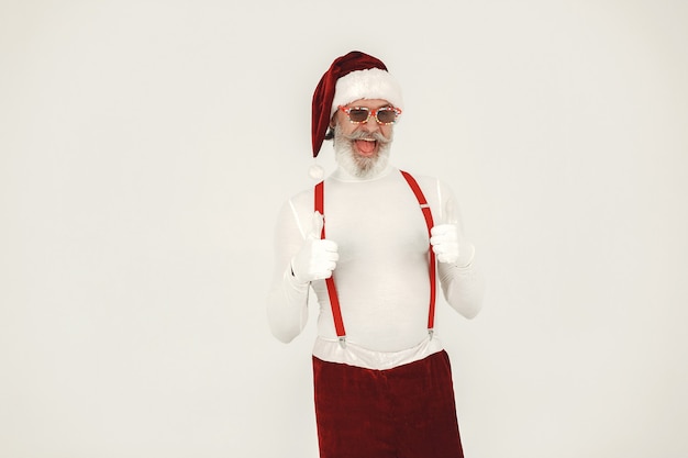 Trendy grey-haired santa. Man wear knitted clothes. Grandfather in a santa's hat.