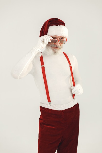 Trendy grey-haired santa. Man wear knitted clothes. Grandfather in a santa's hat.