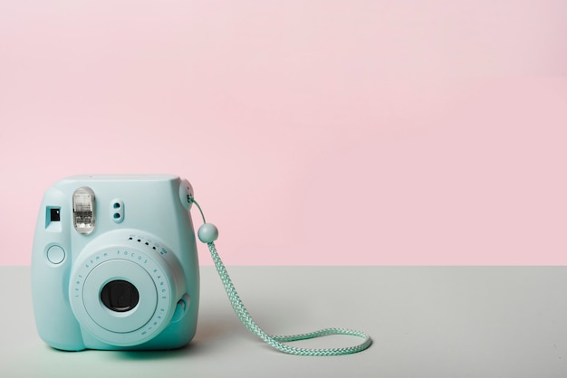 Trendy mini instant camera against pink background