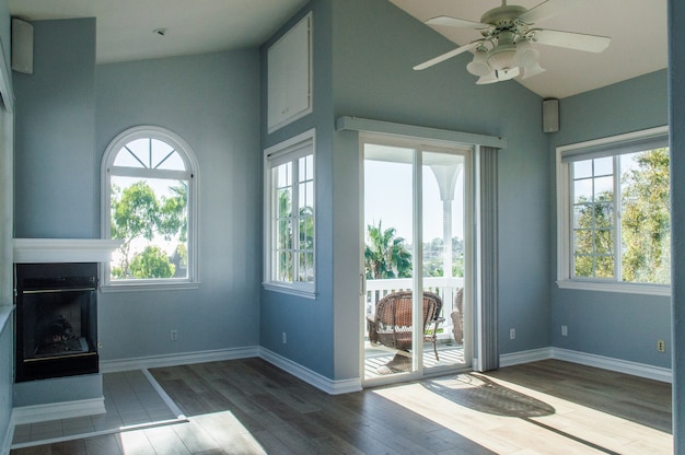 Trendy modern interior of a living room with blue walls and white windows