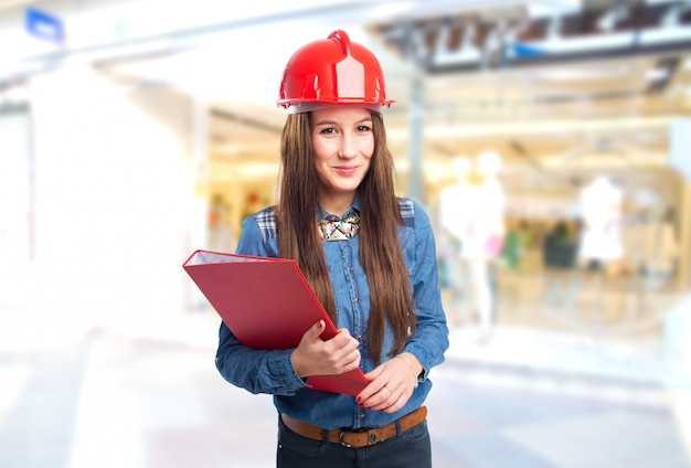 Trendy woman wearing a red helmet and holding a folder