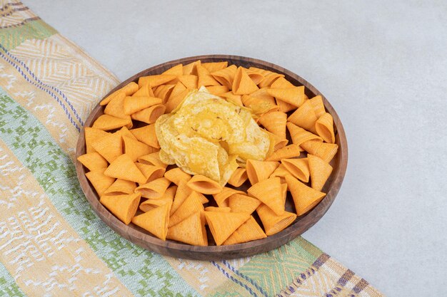 Triangle shaped chips on wooden plate. 