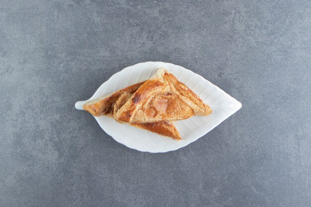 Triangle shaped pastries filled with cheese on white plate.