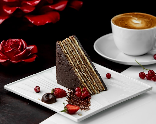 Triangular-shaped cacao layered cake served with berries