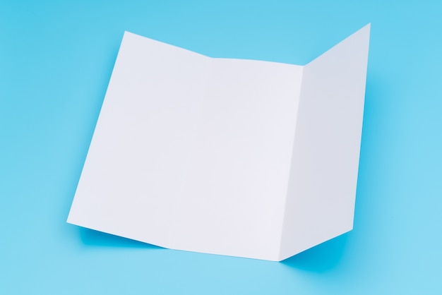 Free photo trifold white template paper on blue background .