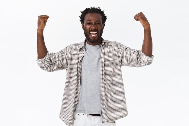 Triumphing lucky african-american bearded guy feeling like champion