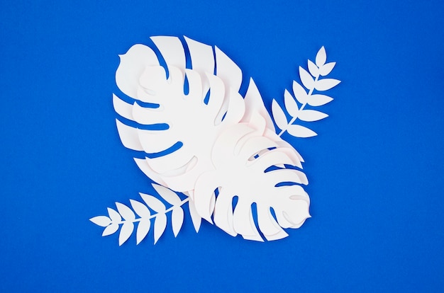 Free photo tropical plants in the style of cut paper on blue background