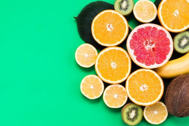 Tropical set of fresh colorful fruits on green background